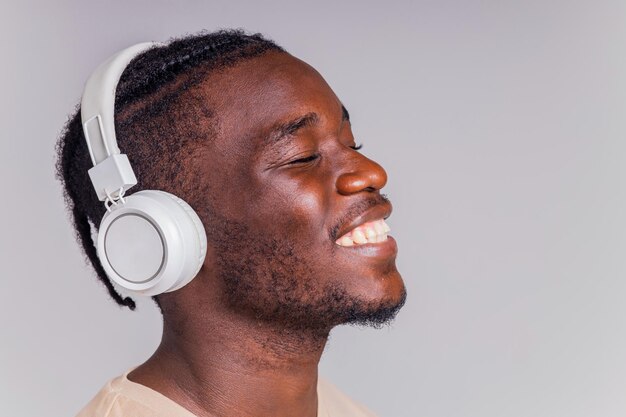 Mexicaanse man met witte koptelefoon die muziek luistert in beige tshirt