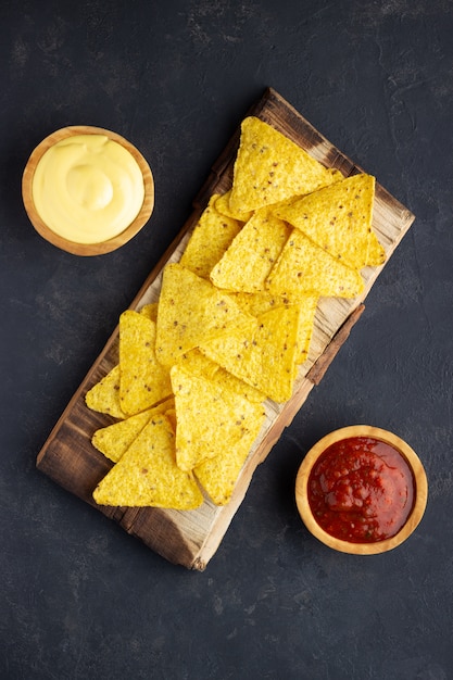 Mexicaanse nacho's met sauzen op een houten bord