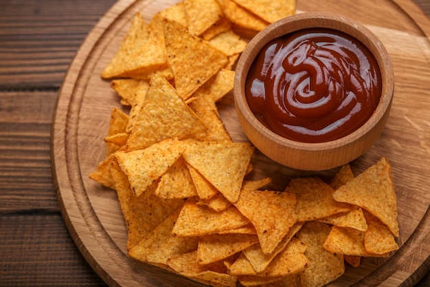 Mexicaanse nachosspaanders met kruidige tomatensaus op houten achtergrond