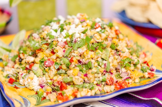 Mexicaanse straat veldsla met gegrilde maïs in grote serveerschaal.