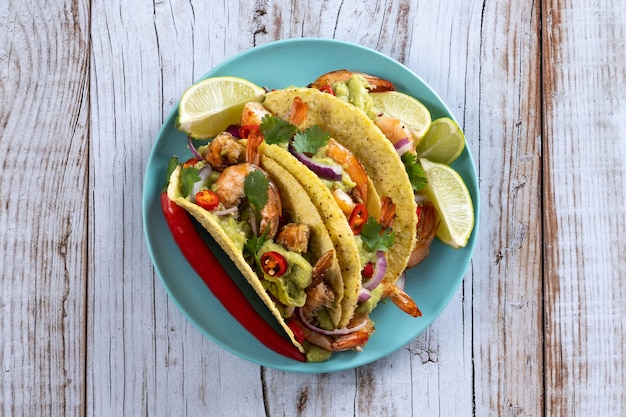 Mexicaanse taco's met garnaalguacamole en groenten op houten tafel