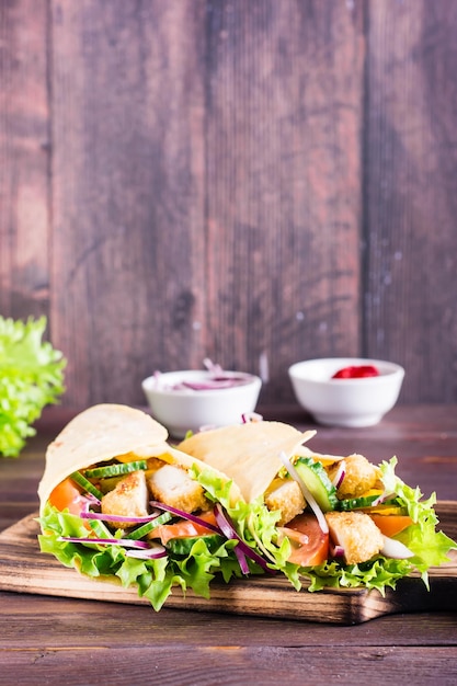 Mexicaanse tortillawraps met kip en groenten op een bord op tafel Verticale weergave