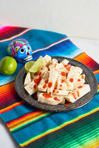 Foto mexicaanse traditionele snack jicama of yam bean met chili chamoy saus en limoen