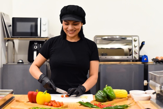 Mexicaanse vrouw die lacht tijdens het koken van taco's in de keuken