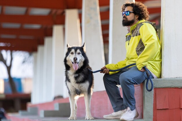 ハスキー犬を持つメキシコのアフロヘアスタイルの男性国際愛犬の日