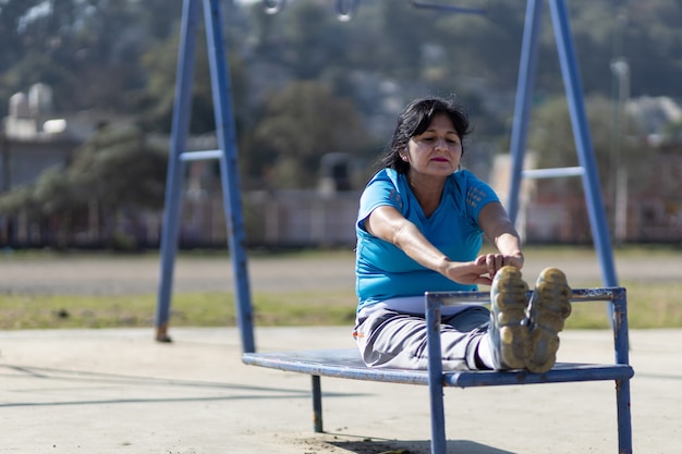 Mexican aged woman training on a playground