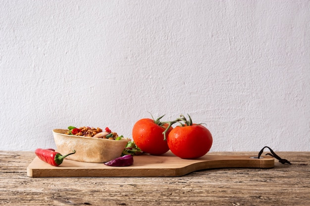 Mexican barquita taco with beef, chilli, tomato, onion and spices on wooden table