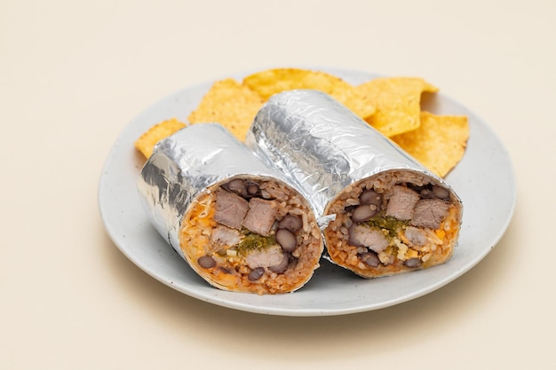 Мексиканский буррито из говядины на маленькой тарелке с чипсами начос