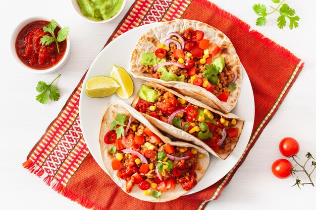 Mexican beef and pork tacos with salsa, guacamole and vegetables