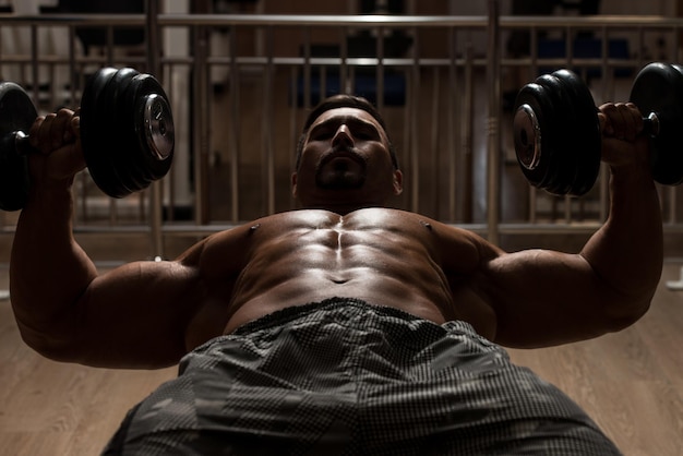 Photo mexican bodybuilder working out chest  dumbbell concentration curls