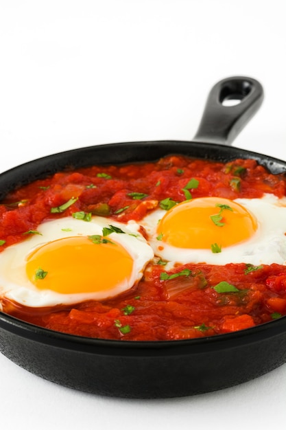 写真 白い背景に分離された鉄のフライパンでメキシコの朝食huevos rancheros