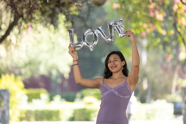 Mexican brunette holding love balloon letters woman39s day self love concept