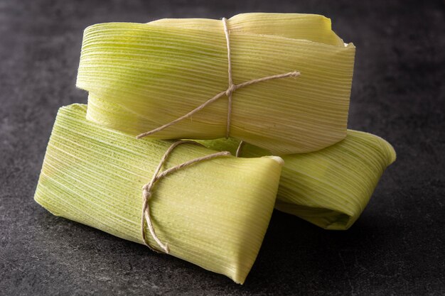 Mexican corn and chicken tamales on black background