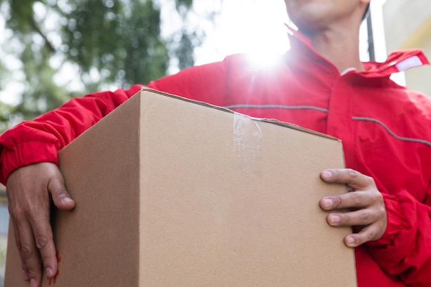 Mexican delivery man holding a big cardboard box