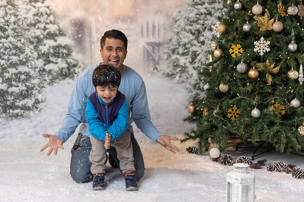 Mexican father and son playing with artificial snow at Christmas time