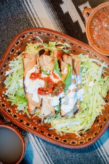 Mexican flautas with lettuce avocado cream sauce and fresh water