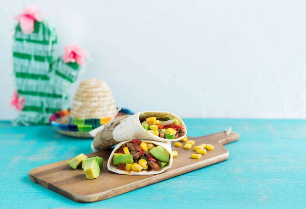 Cibo messicano. burritos sul tavolo da cucina su fondo blu. concetto di cucina messicana. copia spazio.