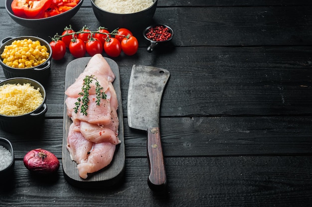 Ingredienti alimentari messicani enchilada di pollo, casseruola di riso, su sfondo nero tavolo in legno con spazio copia per il testo