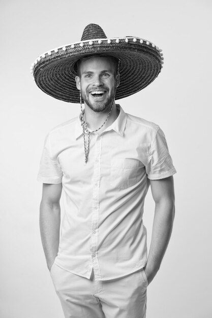 Mexican holiday concept Man cheerful face festive mood posing in sombrero hat yellow background Guy with bristle looks festive in sombrero Man celebrate mexican national traditional holiday