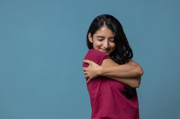 Mexican Latin woman hugging herself tightly