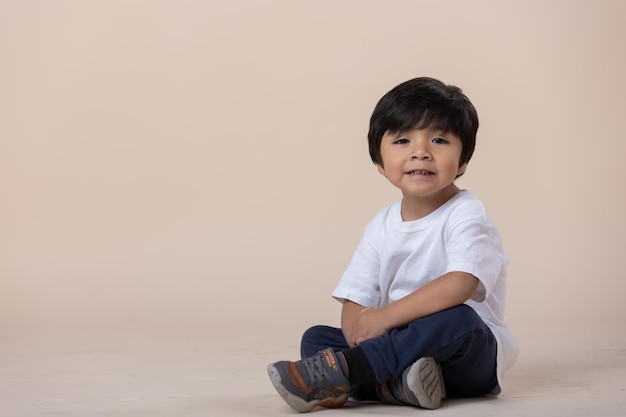 カメラを見て床に座っているメキシコの少年