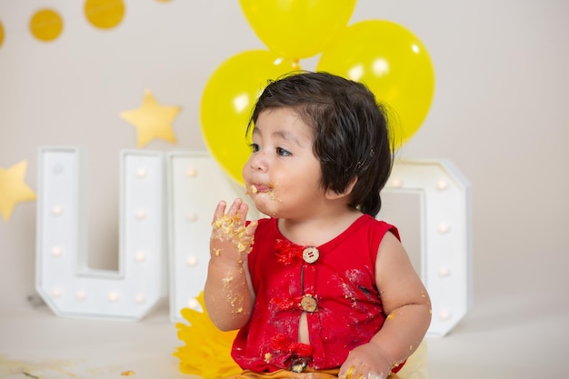 Mexican little boy smashing birthday cake, kids mess