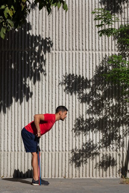 屋外で抵抗輪ゴムでトレーニングするメキシコ人男性