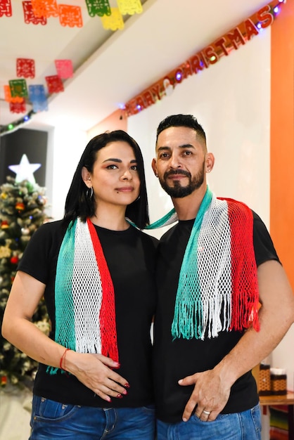 Photo mexican married couple standing against christmas tree