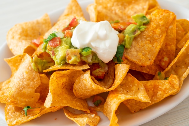 Mexican nachos tortilla chips with jalapeno, guacamole, tomatoes salsa and dip