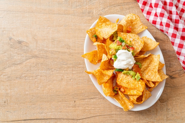 Mexican nachos tortilla chips with jalapeno, guacamole, tomatoes salsa and dip