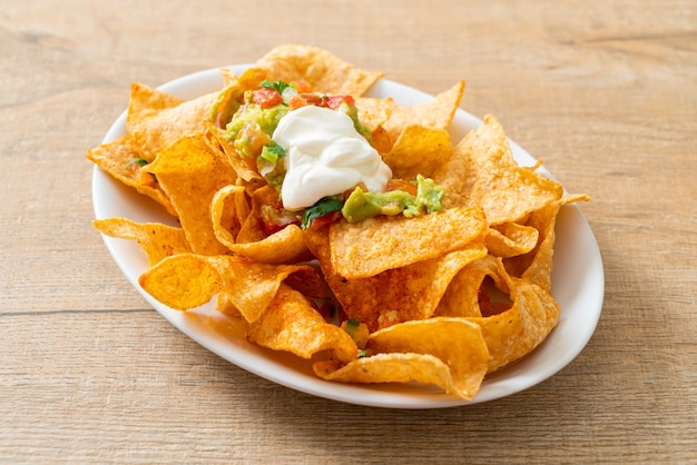 Mexican nachos tortilla chips with jalapeno, guacamole, tomatoes salsa and dip