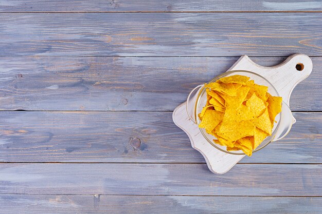 Mexican nachos with cheese. Corn chips isolated on wooden table