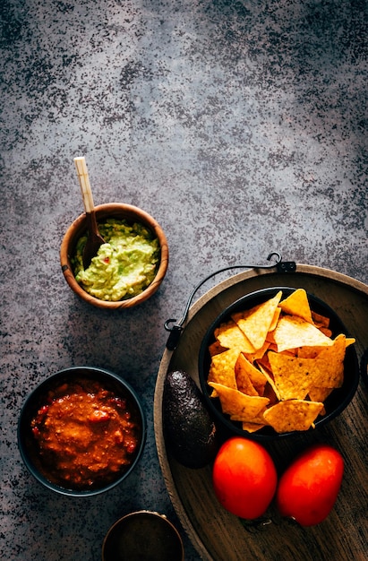 ワカモレ、チェダーチーズ、チリを添えたメキシコのナチョス。典型的なメキシコ料理
