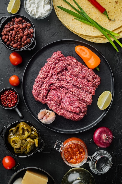 Quesadilla messicana e ingredienti, su sfondo nero, vista dall'alto laici piatta