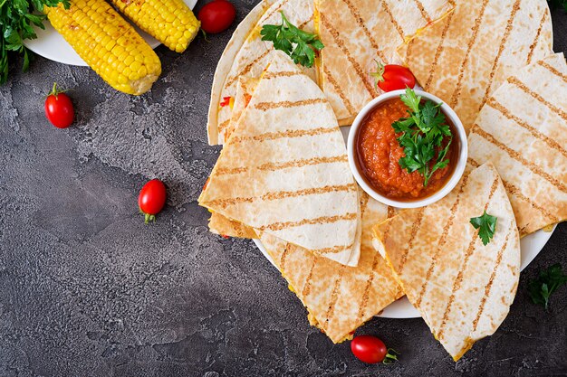 Mexican Quesadilla wrap with chicken, corn and sweet pepper and tomato sauce. Top view. Flat lay