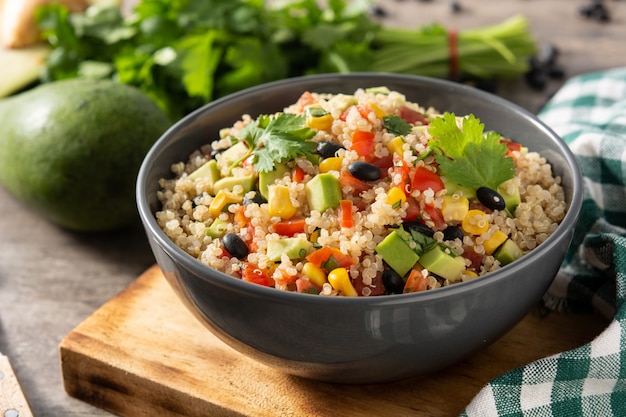 Mexican salad with quinoa in bowl on wooden table