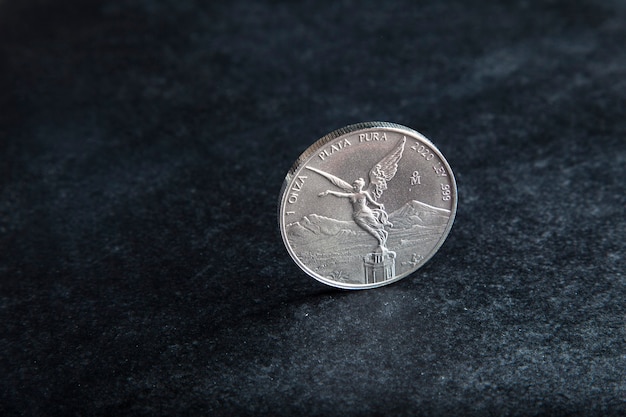 Photo mexican silver coin on black background