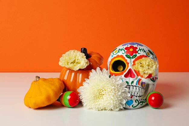 Photo mexican skull zucchini and flowers on orange background