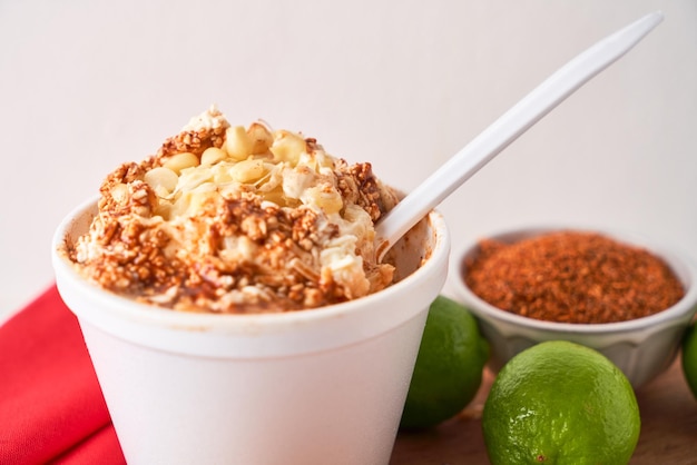 Mexican snack prepared esquite corn in a cup with chili