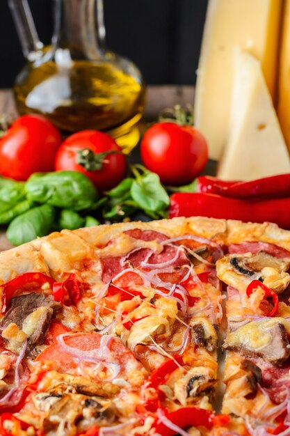 Mexican spicy pizza and ingredients on a wooden table. Traditional Italian cuisine. Party food