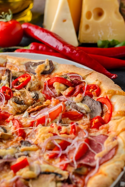 Mexican spicy pizza and ingredients on a wooden table. Traditional Italian cuisine. Party food