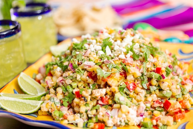 Photo mexican street corn salad with grilled corn in large serving dish.