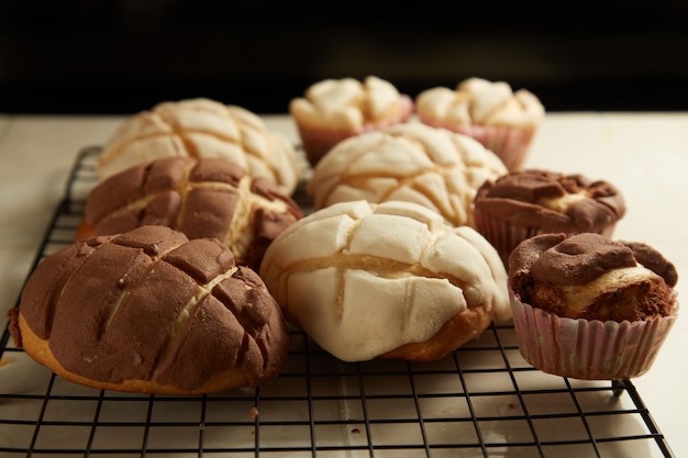 Mexican sweet bread "conchas" and cupcakes in a cooling grid