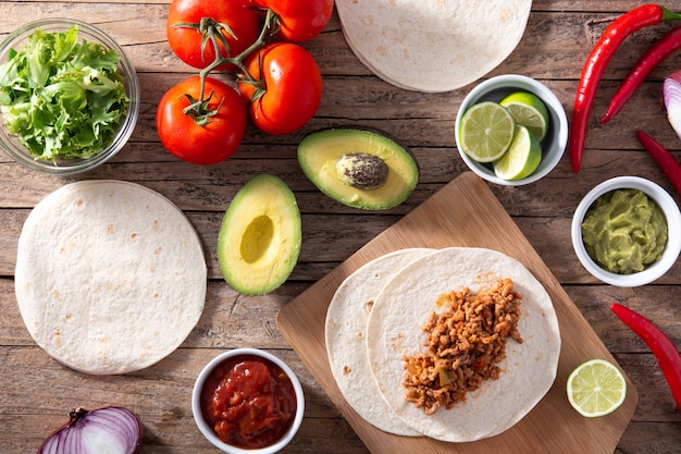 Mexican tacos ingredients on wooden table