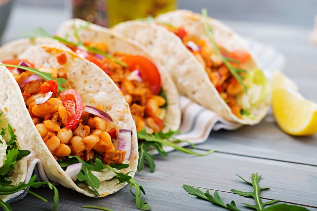 Mexican tacos with beef, beans in tomato sauce and salsa