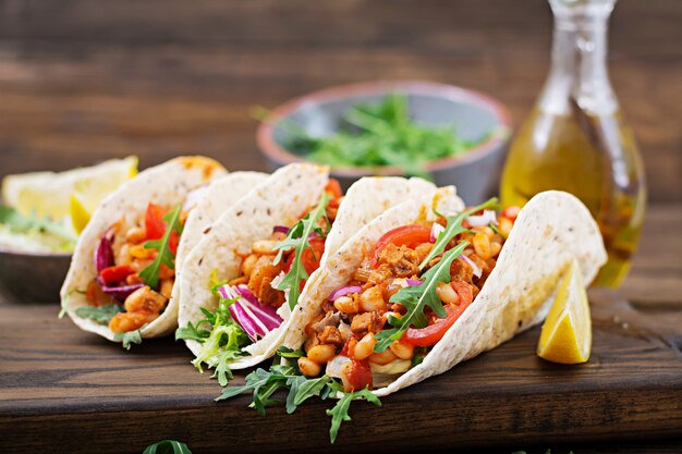 Mexican tacos with beef, beans in tomato sauce and salsa