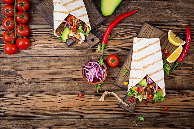 Mexican tacos with beef in tomato sauce and avocado salsa. Flat lay. Top view