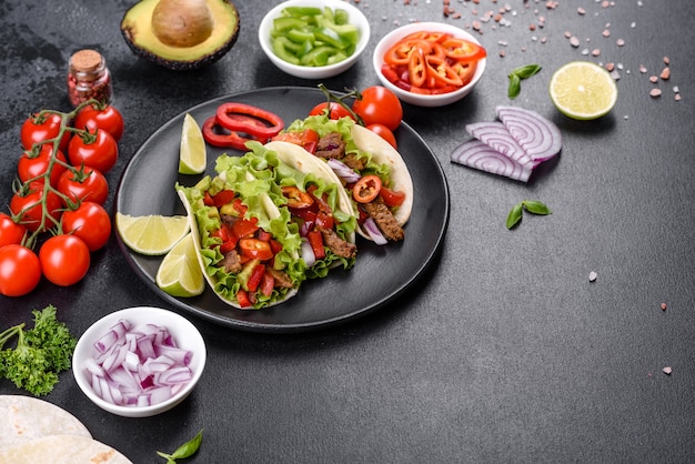 Mexican tacos with beef, tomatoes, avocado, onion and salsa\
sauce