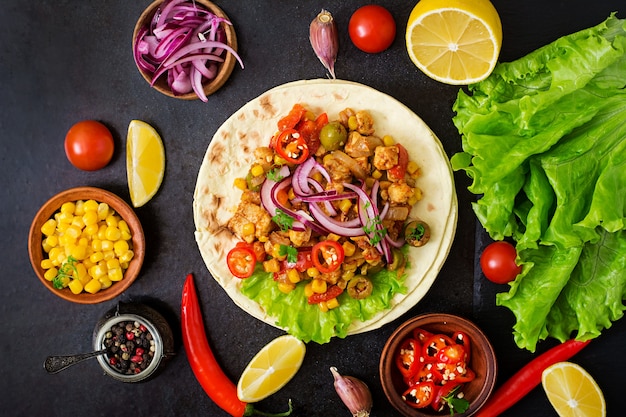 Mexican tacos with meat, corn and olives on dark background. Top view