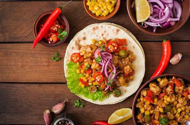 Mexican tacos with meat, corn and olives on wooden background. Top view